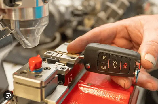 photo of auto key fob being cut and programmed by locksmith