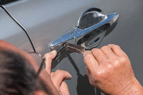 locksmith helping someone open their car lock aka lockout